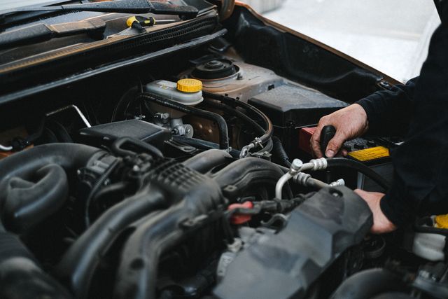 Handen met gereedschap in de open motorruimte